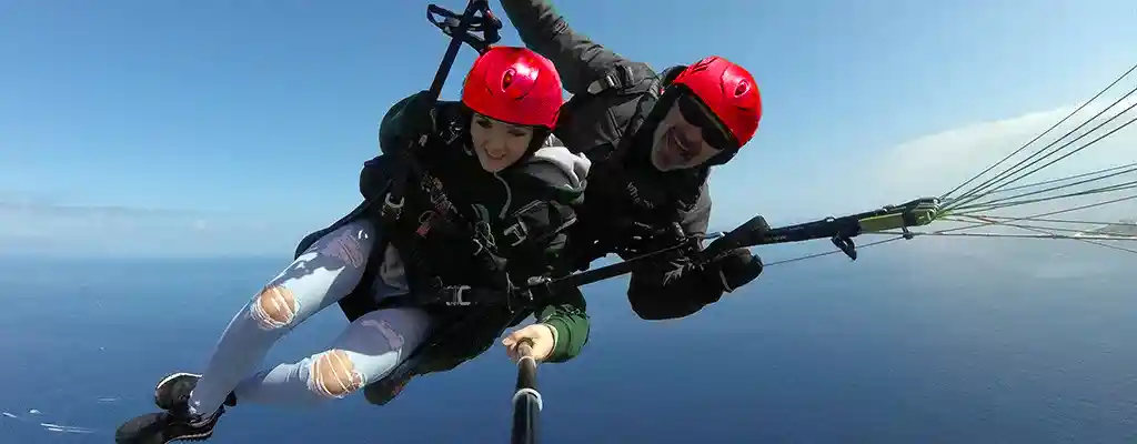 آکادمی آموزش پاراگلایدر تهران 22 خلبان پاراگلایدر در حال پرواز بر فراز دریا در روزی آفتابی